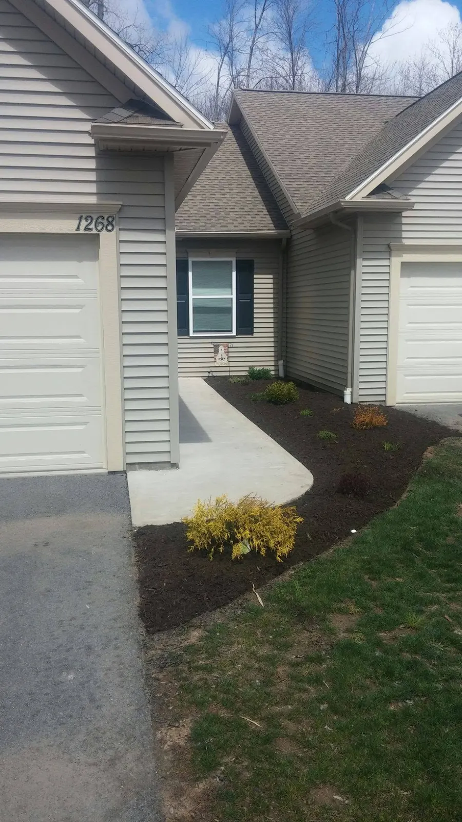 Edged lawn and mulched bed along the side of a home in Webster, NY