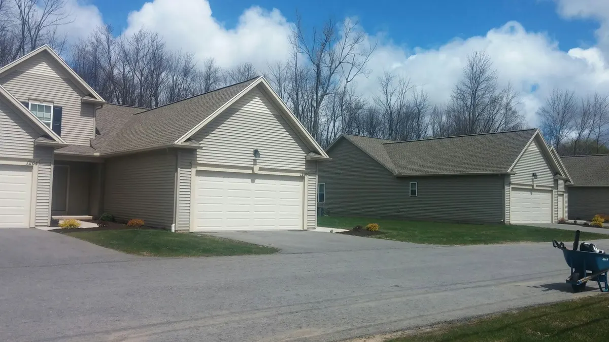 Neatly mowed lawn beside a detached garage in Webster, NY
