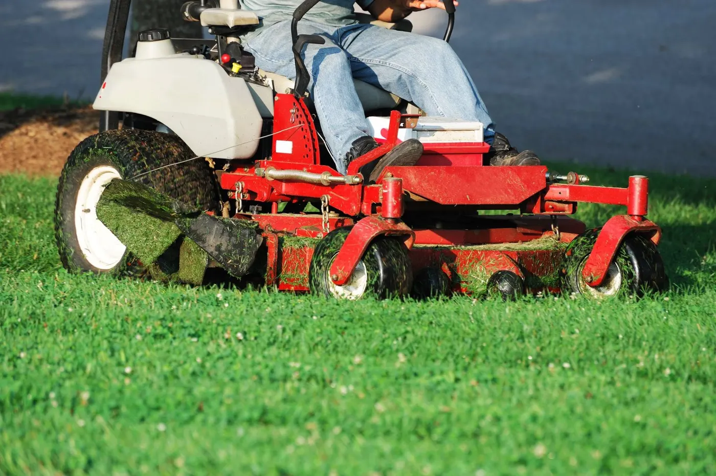 Red zero-turn mower on a green residential lawn in Webster, NY
